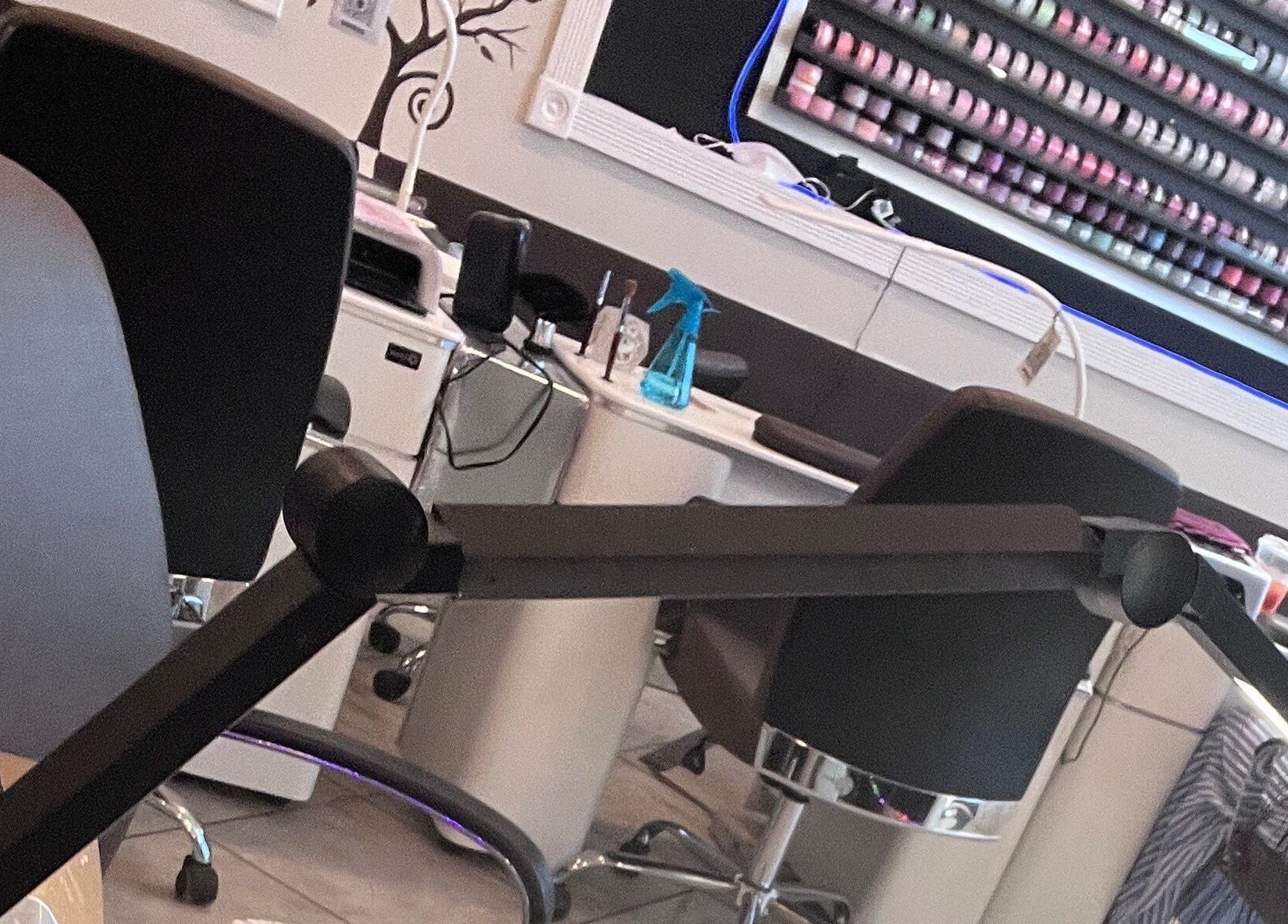Sophisticated manicure setup at Kiwiinails Pro, Fenton, Michigan, US, showcasing polish selection and elegant seating.