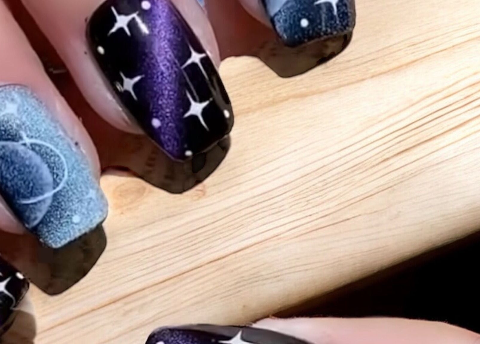 Kiwiinails Pro in Fenton, Michigan offers stunning galactic-themed nail art with starry night designs.