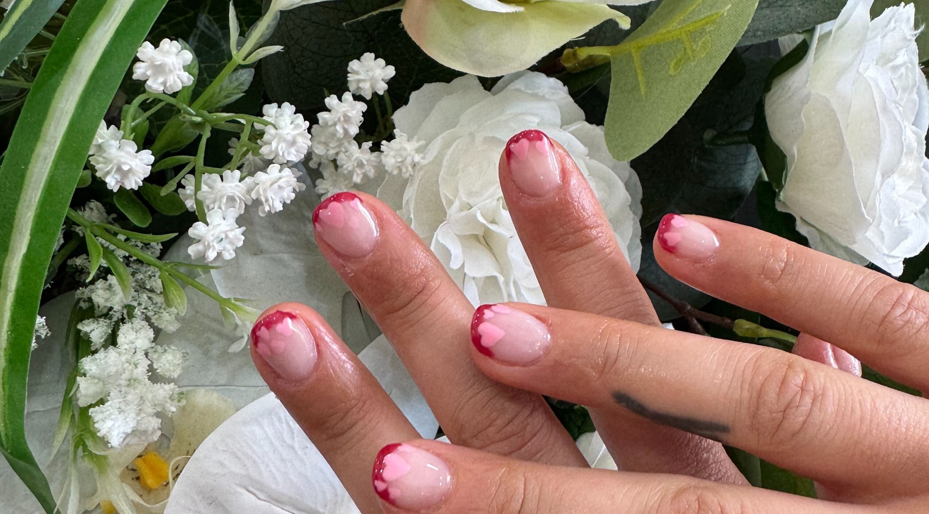 Elegant pink heart nail art with floral backdrop at Magnolia Beauty Bar, Mildura, Victoria, AU.