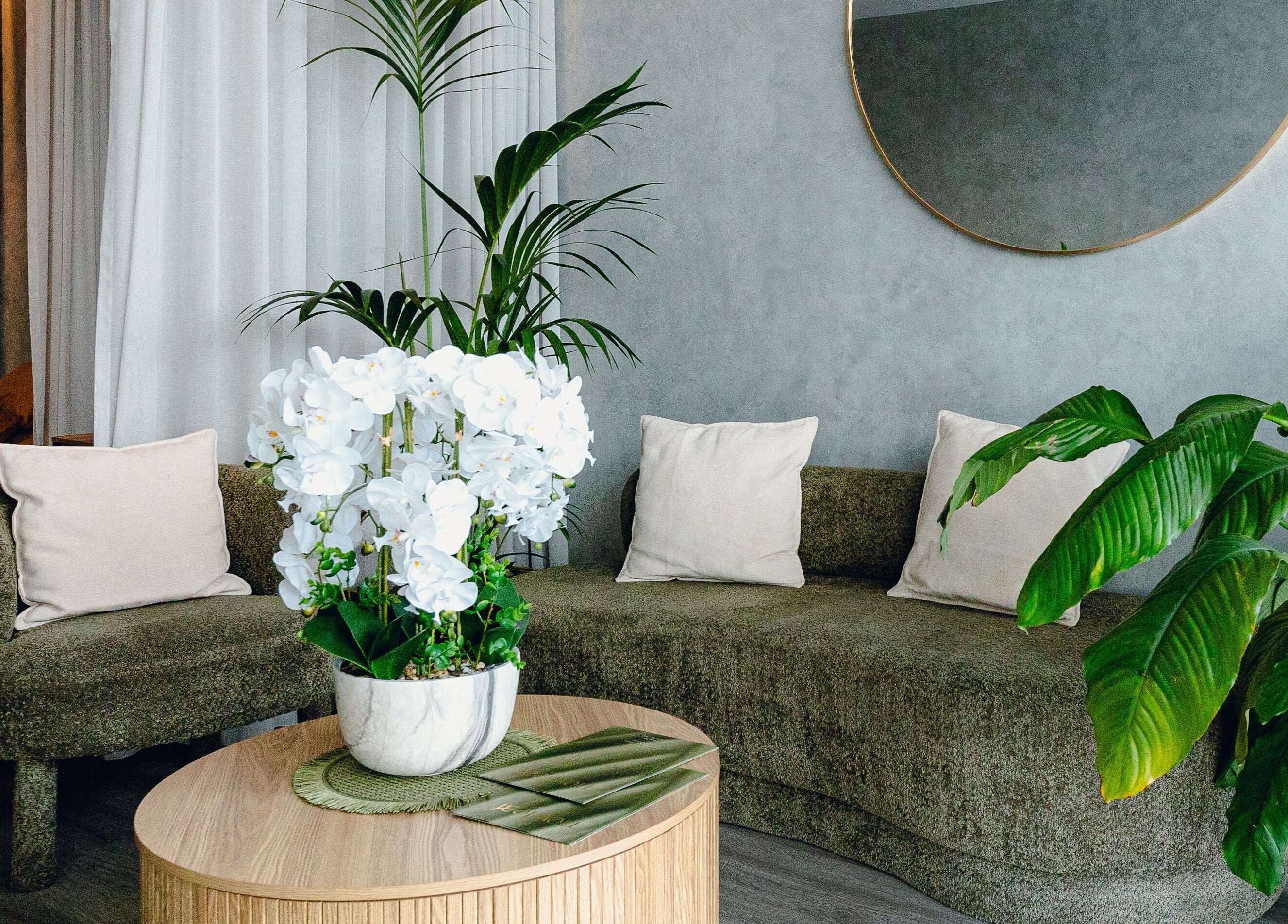Elegant lounge at Newleaf Spa, Melbourne, Victoria, AU, with cozy seating and lush plants.