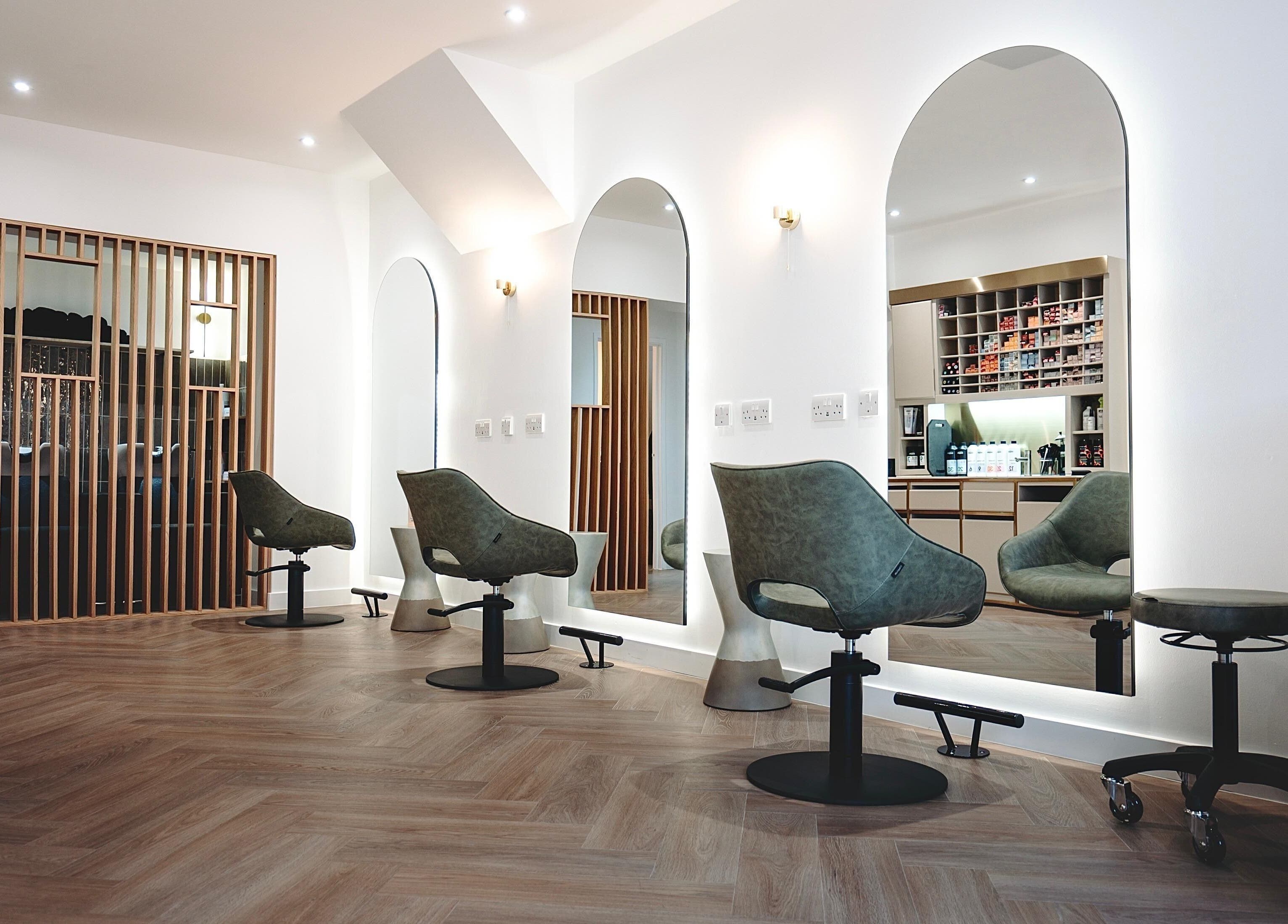 Modern salon interior at Flow in Royal Tunbridge Wells, England, GB with stylish mirrors and chairs.