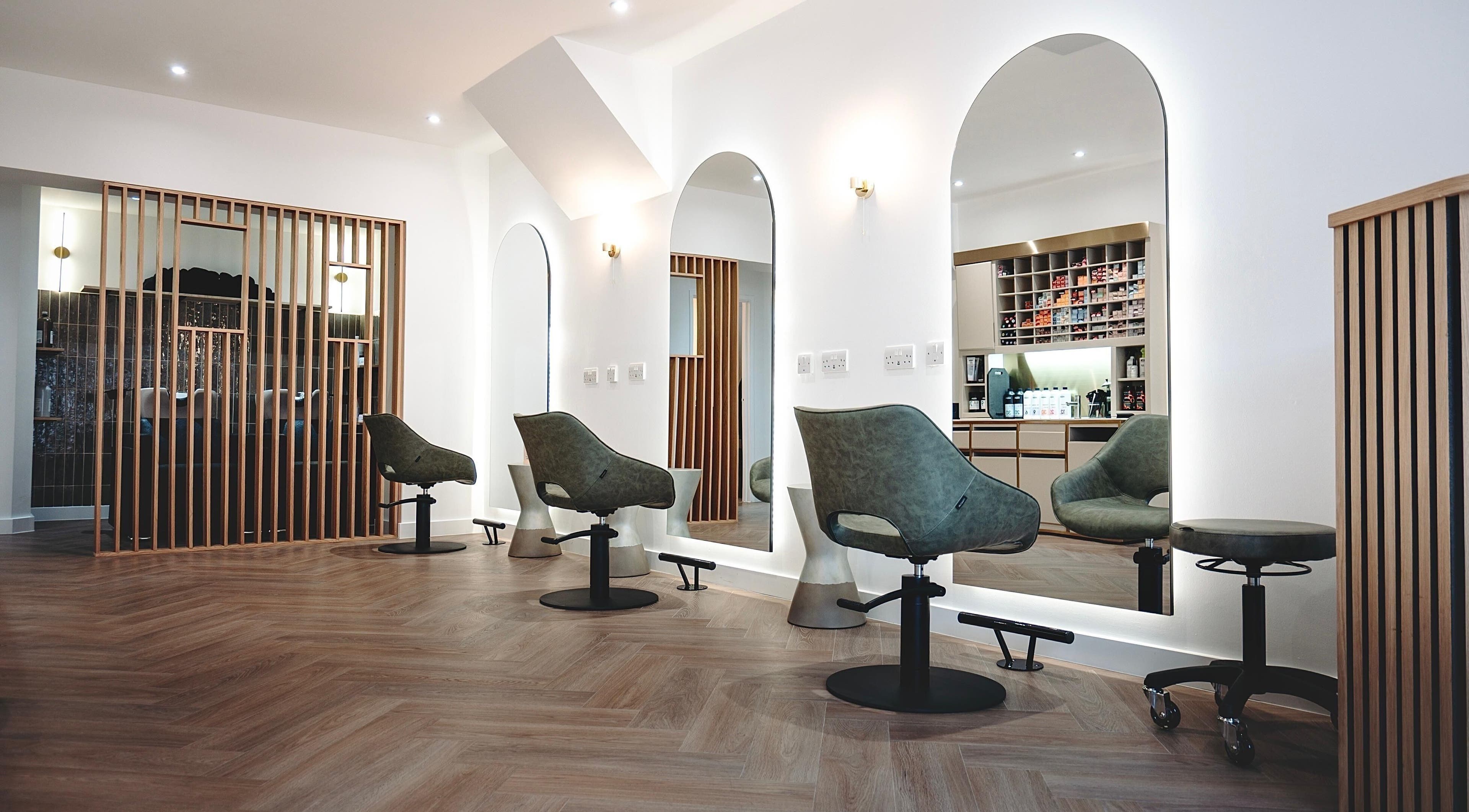 Modern salon interior at Flow in Royal Tunbridge Wells, England, GB with stylish mirrors and chairs.
