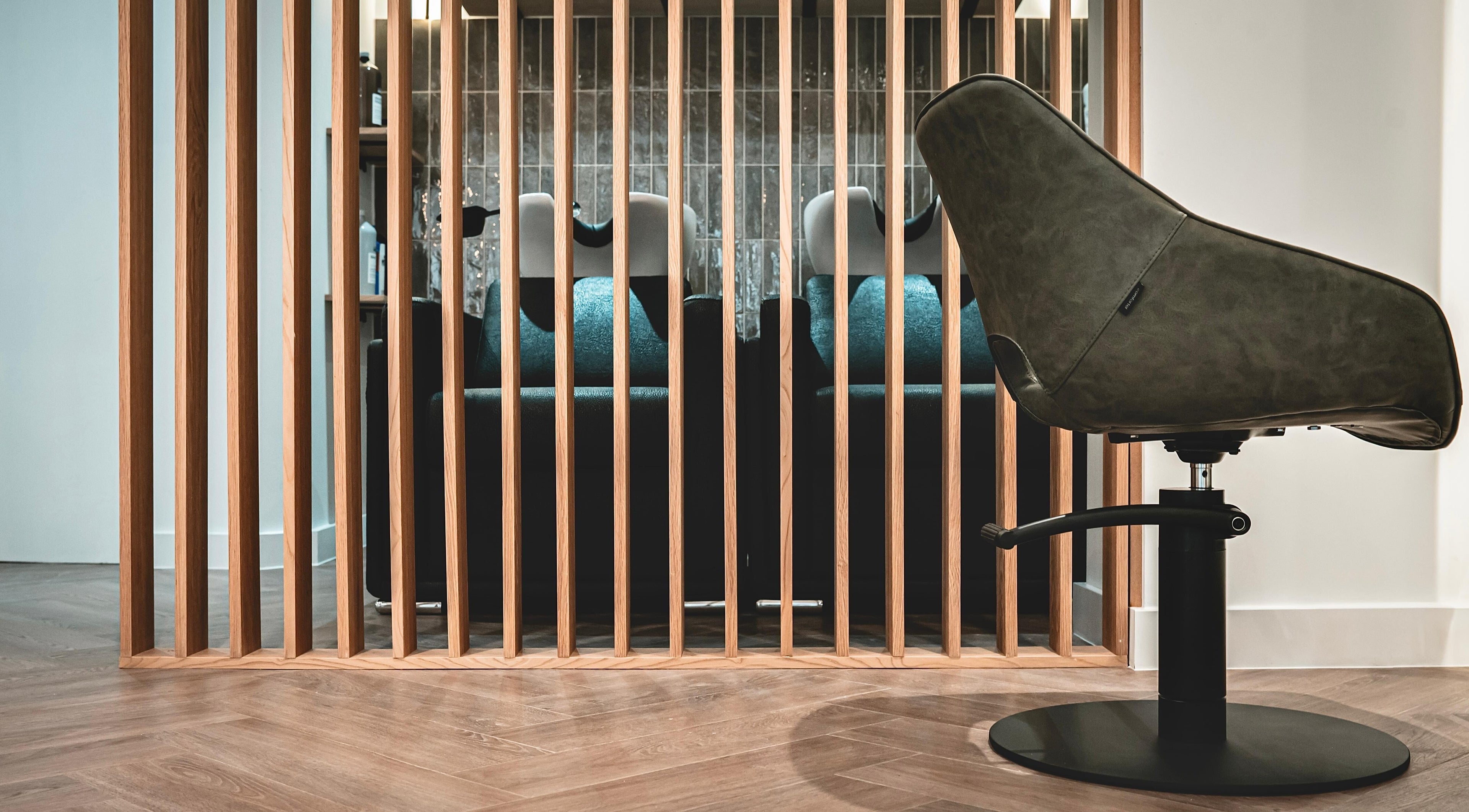 Modern salon chair and wood panel room divider at Flow, Royal Tunbridge Wells, England, GB.