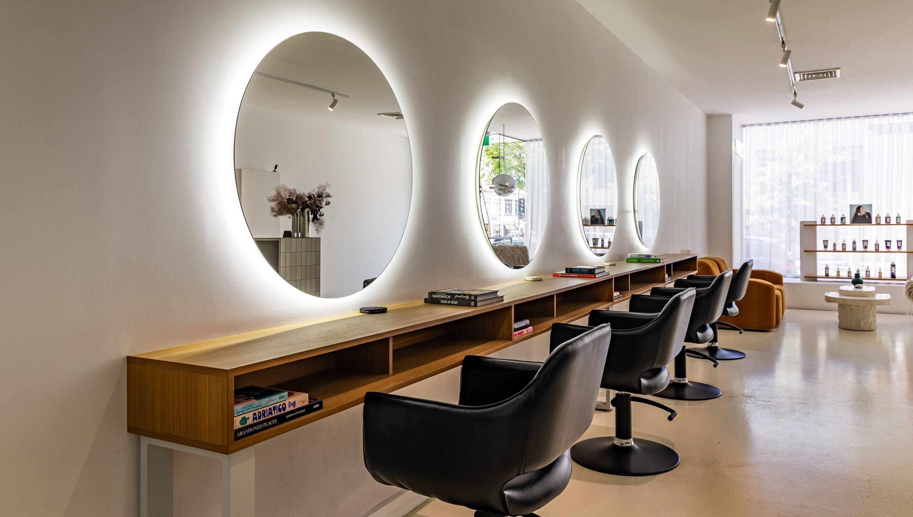 Elegant salon interior at WAVES in Melbourne, Victoria, AU highlighting modern chairs and glowing mirrors.