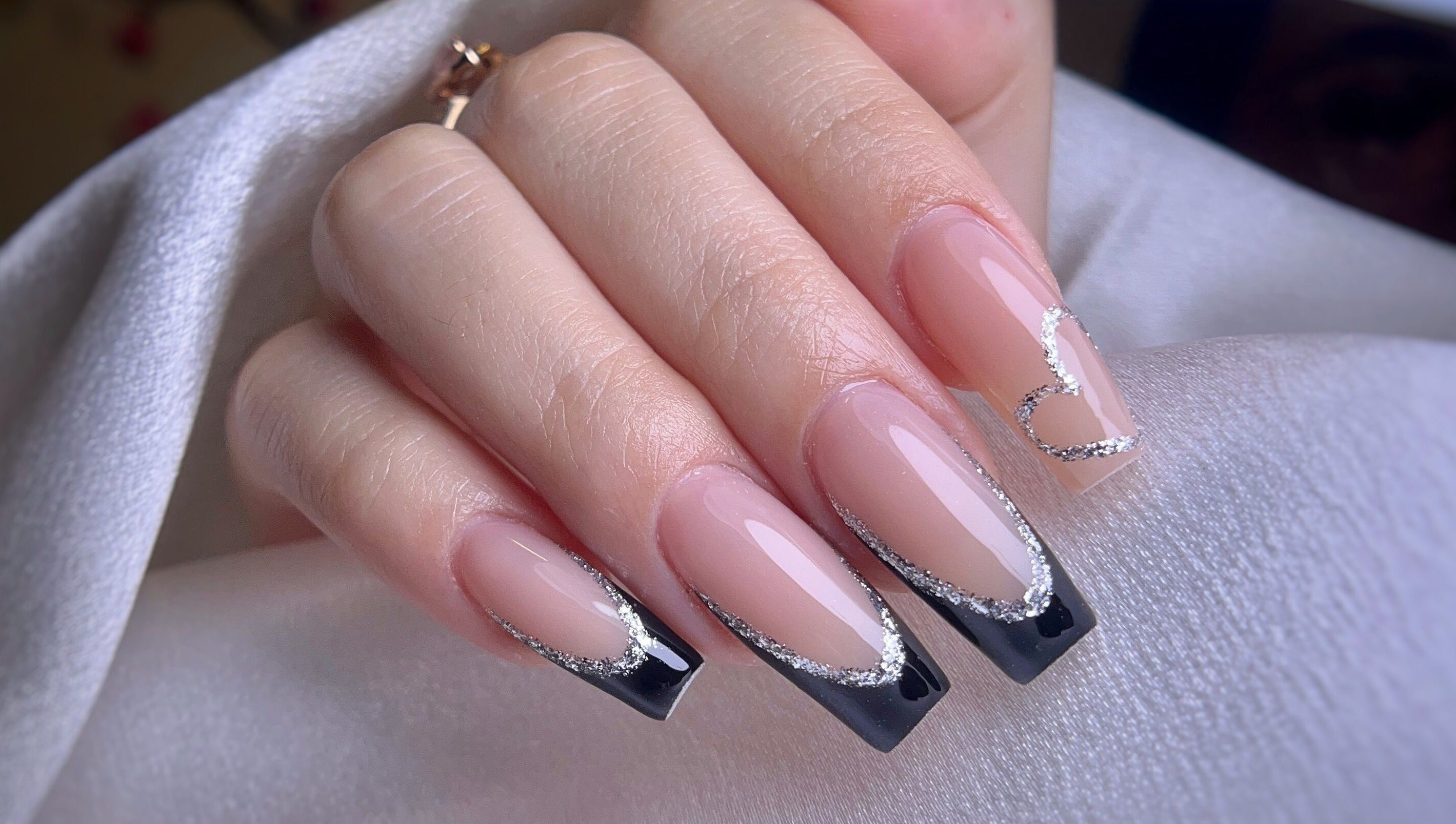 Arte de uñas elegante con diseño en negro y plateado en Yoss Nails, Memphis, Tennessee, US.