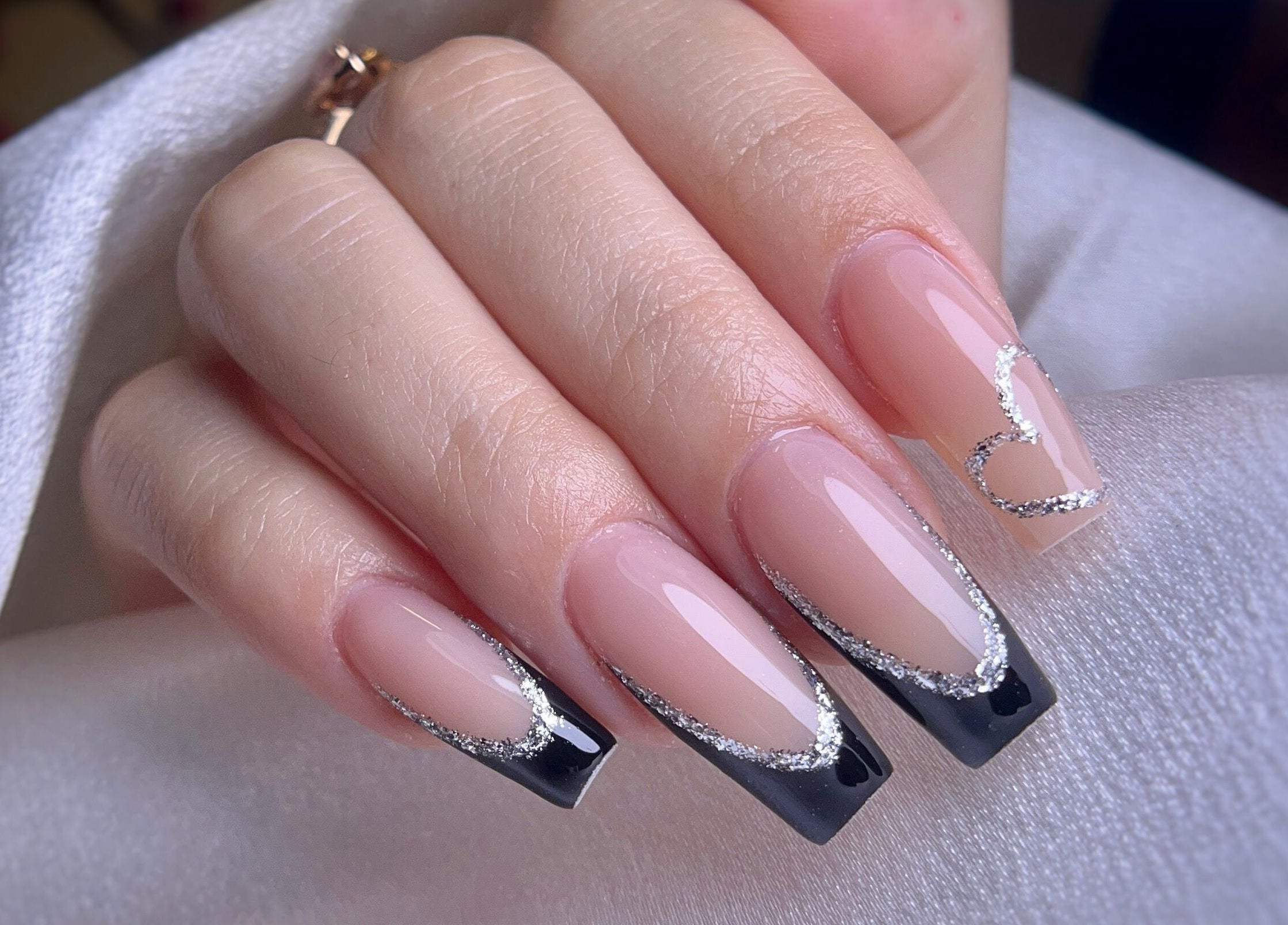 Arte de uñas elegante con diseño en negro y plateado en Yoss Nails, Memphis, Tennessee, US.