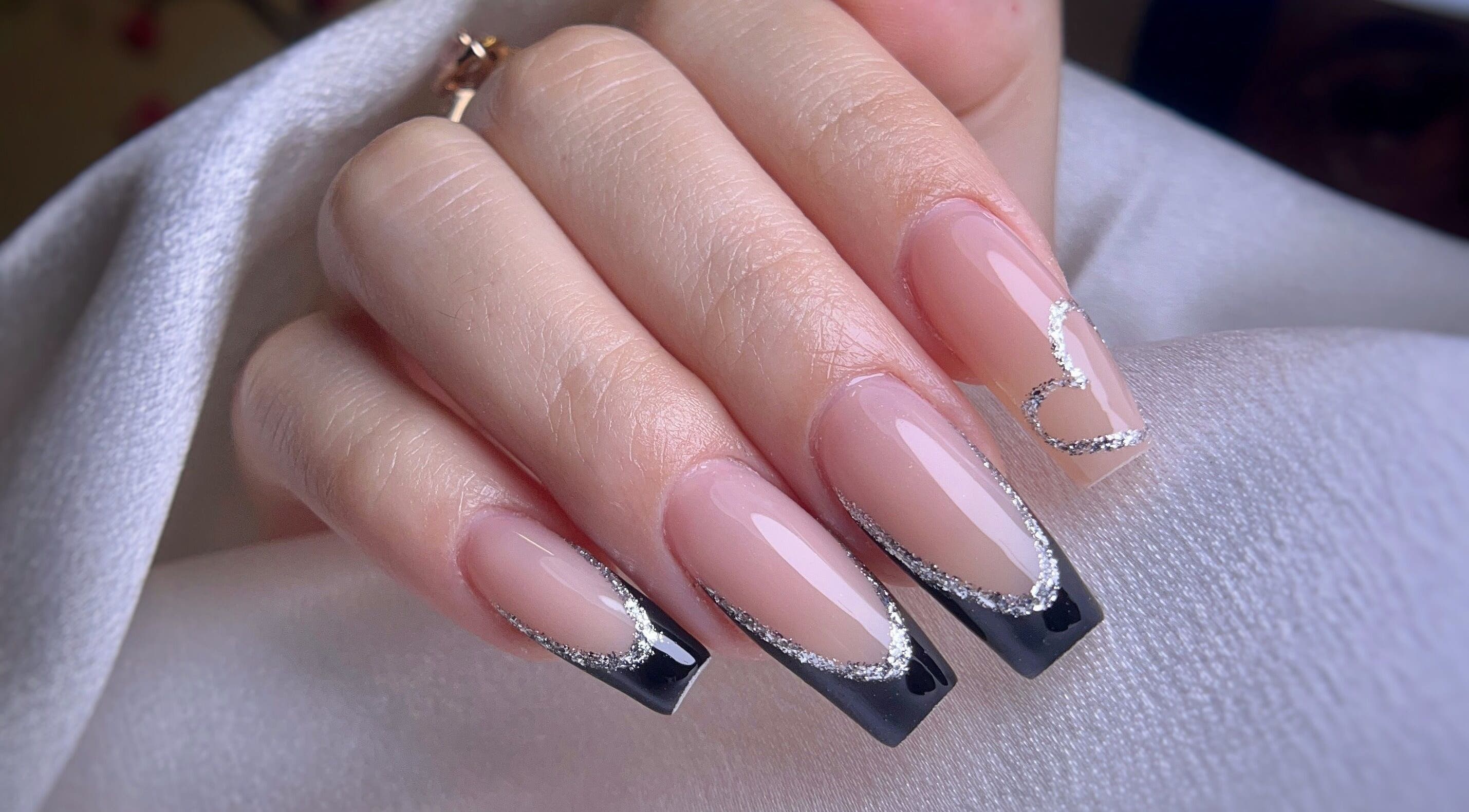 Arte de uñas elegante con diseño en negro y plateado en Yoss Nails, Memphis, Tennessee, US.