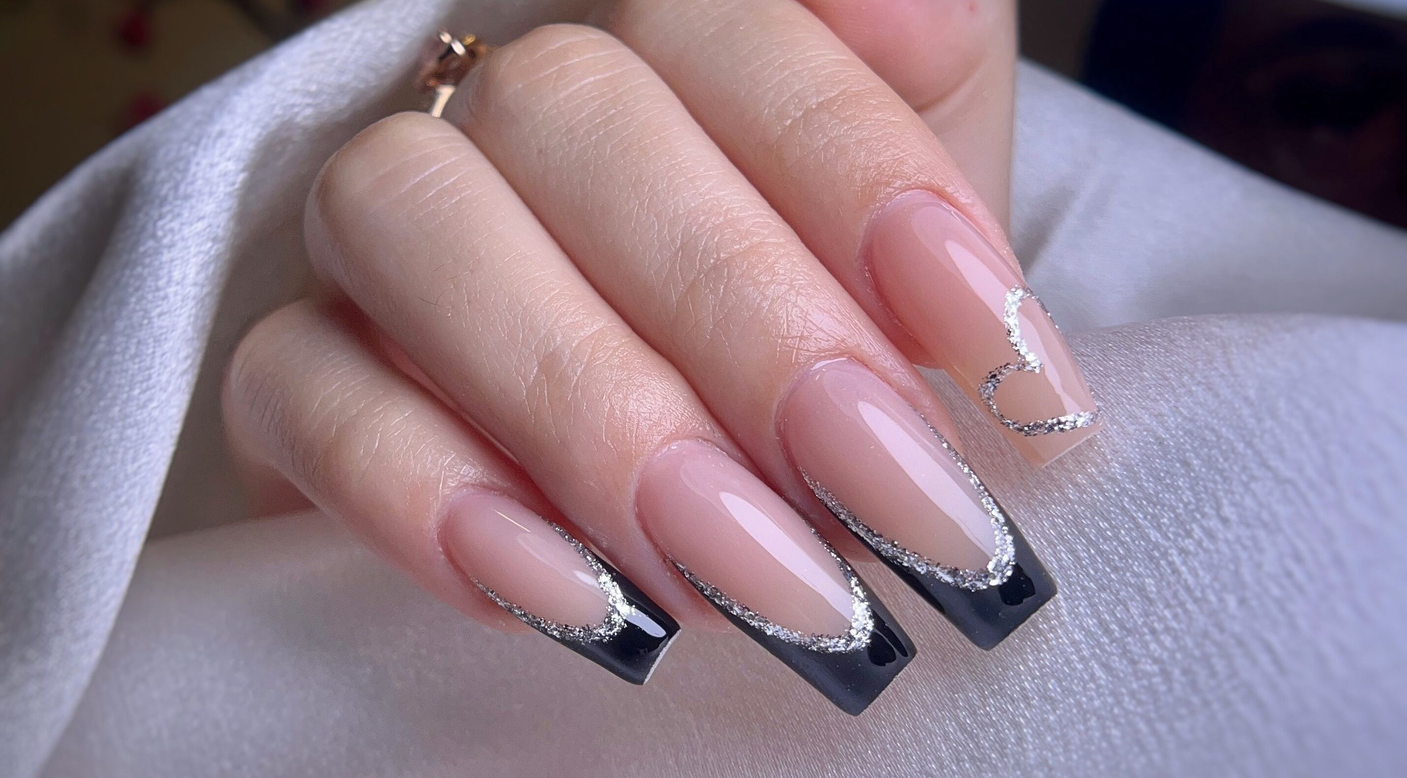 Arte de uñas elegante con diseño en negro y plateado en Yoss Nails, Memphis, Tennessee, US.