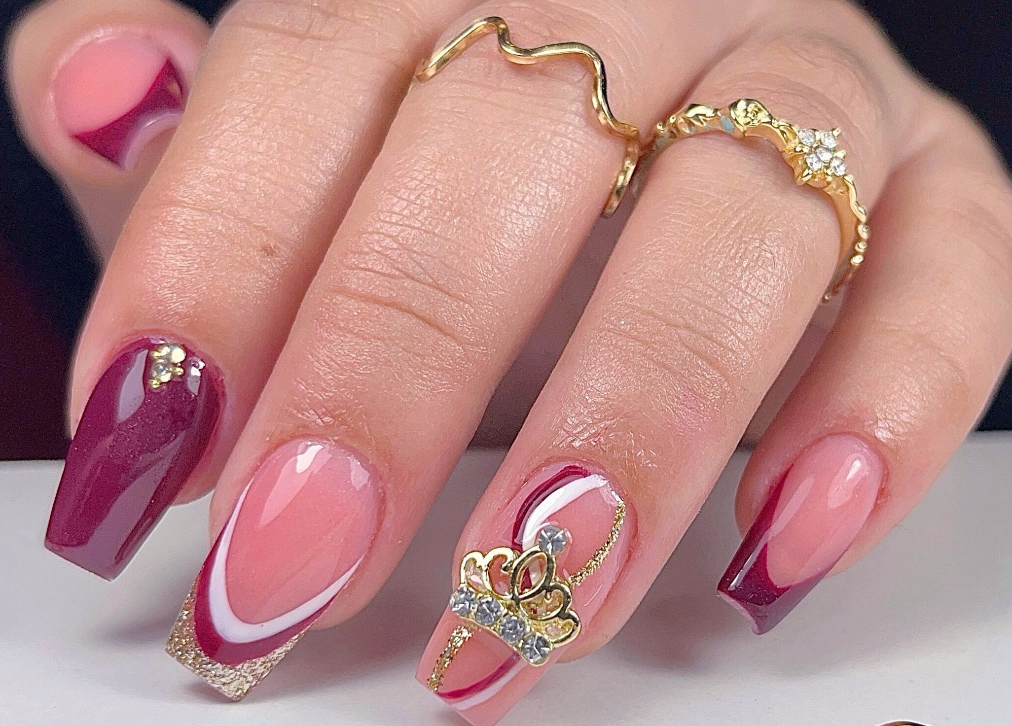 Elegante diseño de uñas con detalles dorados en Yoss Nails, Memphis, Tennessee, US.