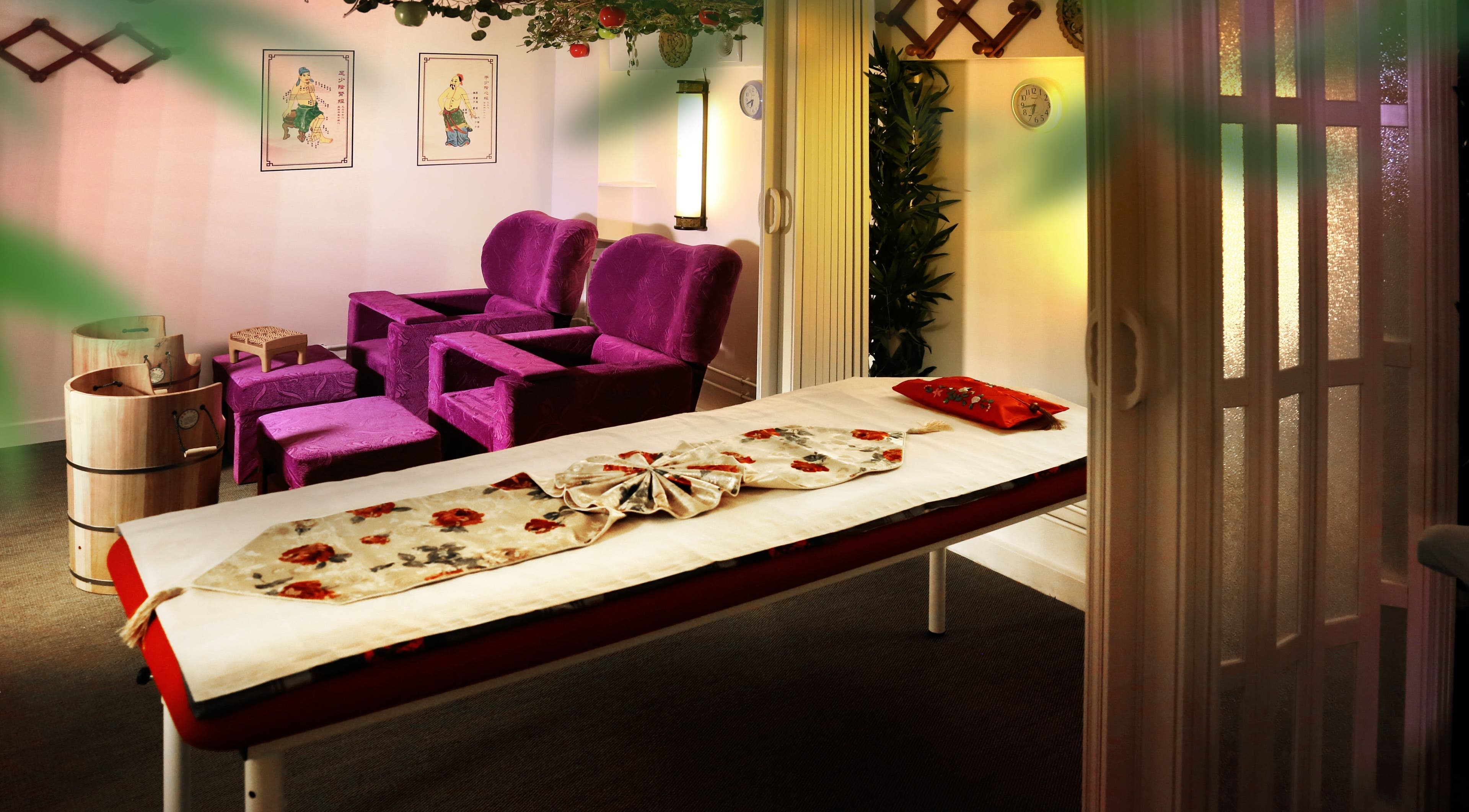 Salle de soins apaisante de Lanqi Spa - 7è à Paris, Île-de-france, FR, avec fauteuils violets et table de massage.