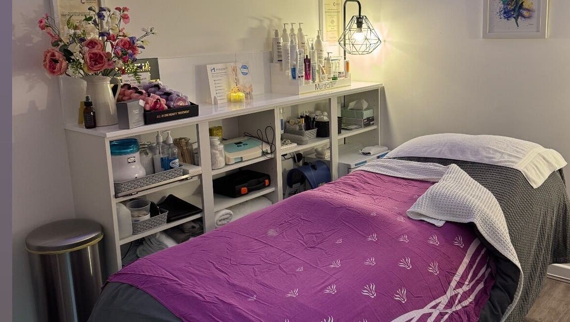 Cozy treatment room at Pennyfeathers, Saint Saviour, featuring a massage bed and skincare products.