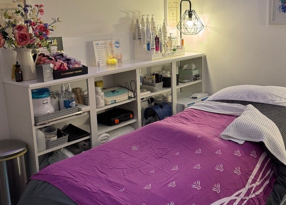 Cozy treatment room at Pennyfeathers, Saint Saviour, featuring a massage bed and skincare products.