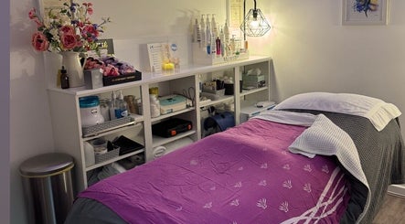 Cozy treatment room at Pennyfeathers, Saint Saviour, featuring a massage bed and skincare products.