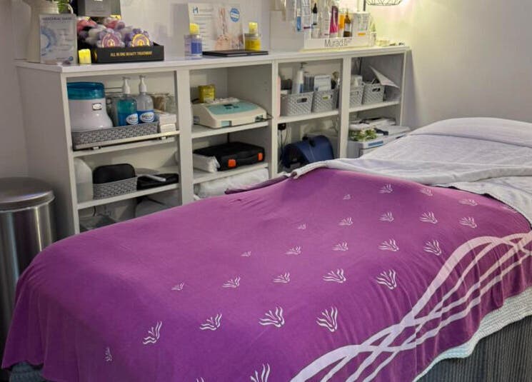 Cozy treatment bed at Pennyfeathers, Saint Saviour, GB, adorned with a purple blanket for relaxation.