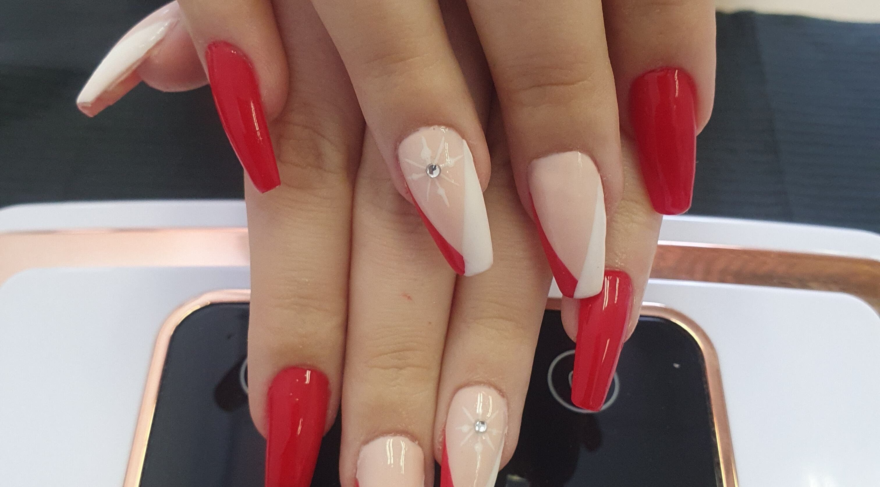 Elegant red manicure with gem accents at BeBe, Cape Town, Western Cape, ZA.