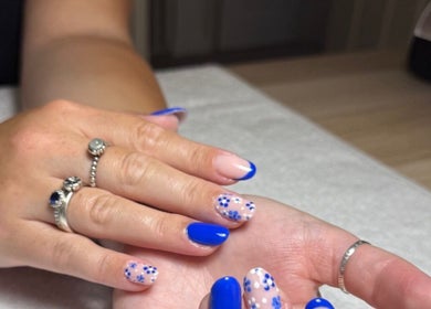 Elegant blue floral nail art at The Nail Vault in Plymouth, England, GB, showcasing creativity and style.