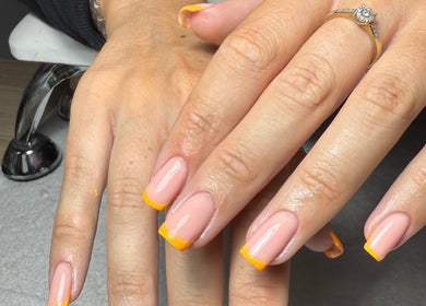 Fresh orange-tipped manicure at The Nail Vault, Plymouth, England, GB showcasing perfect nail art.