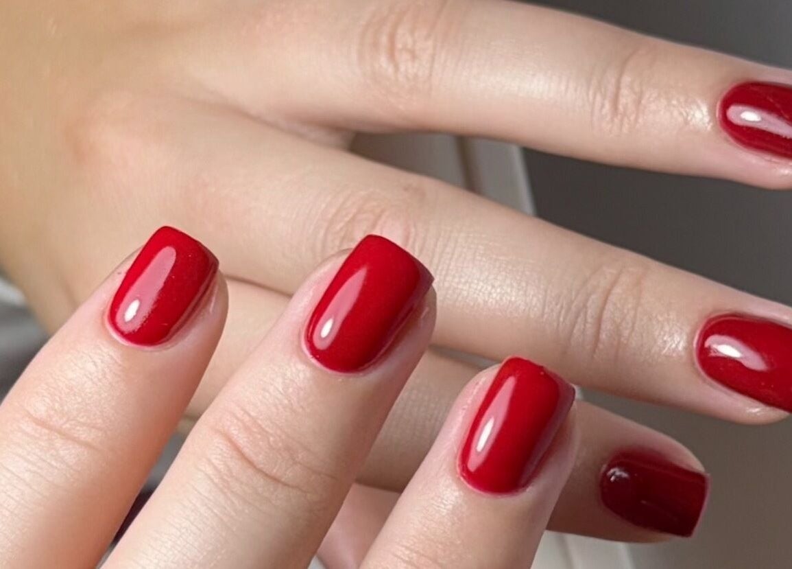 Vibrant red manicure at The Nail Vault in Plymouth, England, GB showcasing elegant nail design.