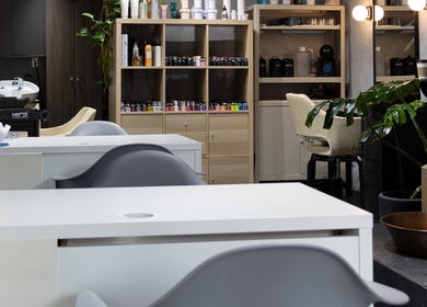 Interior moderno del Hula Studio en Ciudad De México, MX, mostrando estaciones de belleza y plantas.
