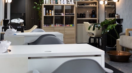 Interior moderno del Hula Studio en Ciudad De México, MX, mostrando estaciones de belleza y plantas.