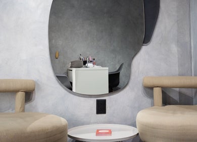 Interior acogedor de Hula Studio, Ciudad De México, con sillas beige y espejo moderno.