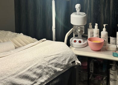 Cozy treatment room at 27Skin in Lingfield, England equipped with skincare products and soft towels.