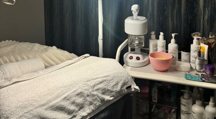 Cozy treatment room at 27Skin in Lingfield, England equipped with skincare products and soft towels.