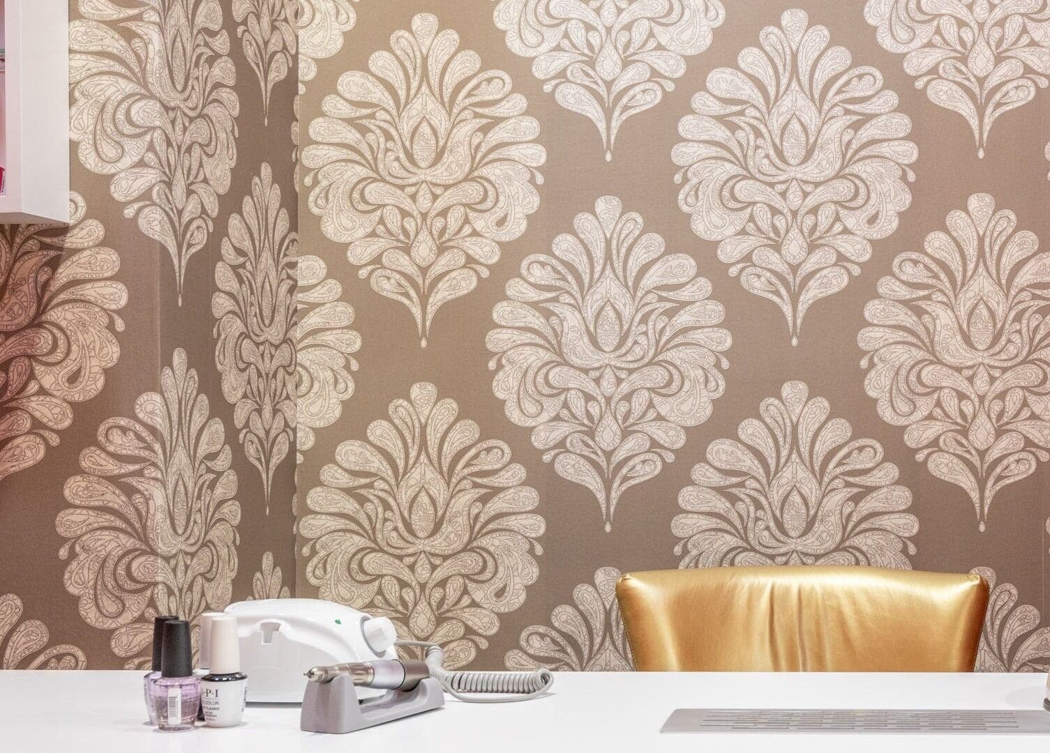 Stylish manicure station at Raskoljnikov Beauty Studio, Београд, RS, featuring elegant wallpaper and nail polish.