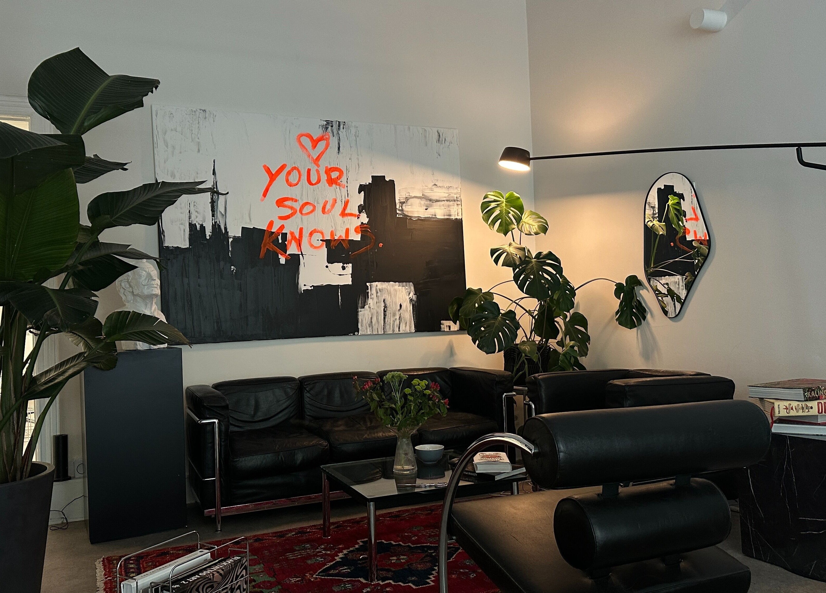 Cozy lounge at Usee Tattoo Studio, Berlin with art and plants creating a welcoming atmosphere.