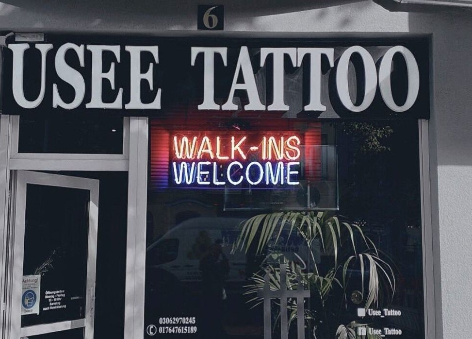 Front of Usee Tattoo Studio in Berlin, featuring a neon sign 'WALK-INS WELCOME'.