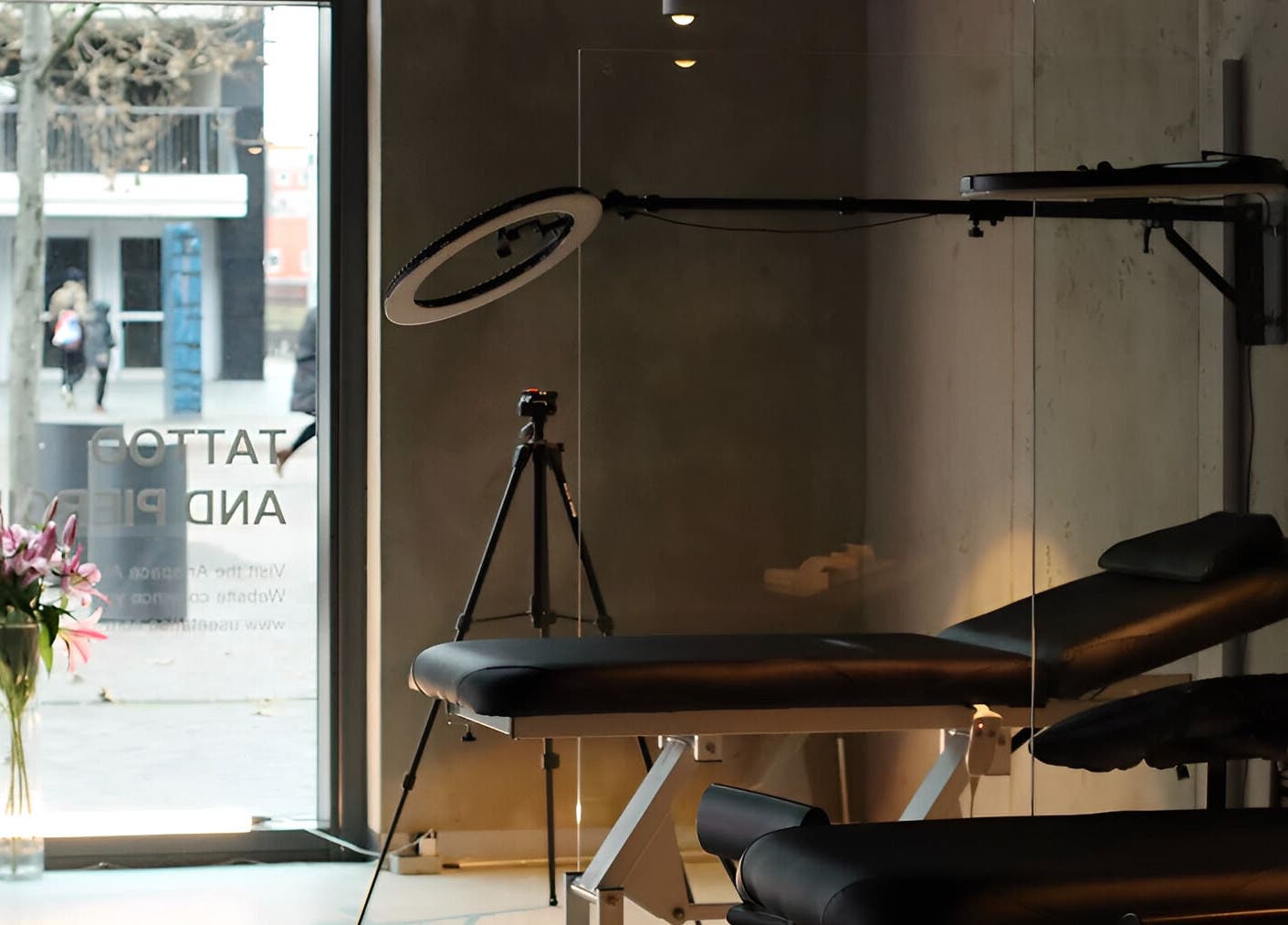 Calm interior of Usee Tattoo Atelier in Berlin, Berlin, DE, featuring a tattoo bed, tripod, and flowers.