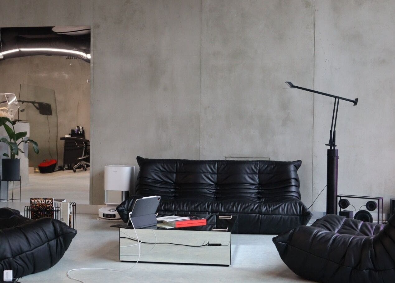 Sleek, modern lounge area at Usee Tattoo Atelier, Berlin, Berlin, DE featuring plush black seating.