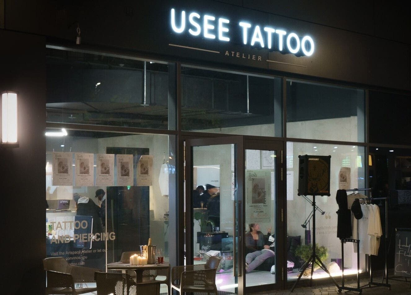 Exterior night view of Usee Tattoo Atelier in Berlin, Berlin, DE, with illuminated signage and entrance.