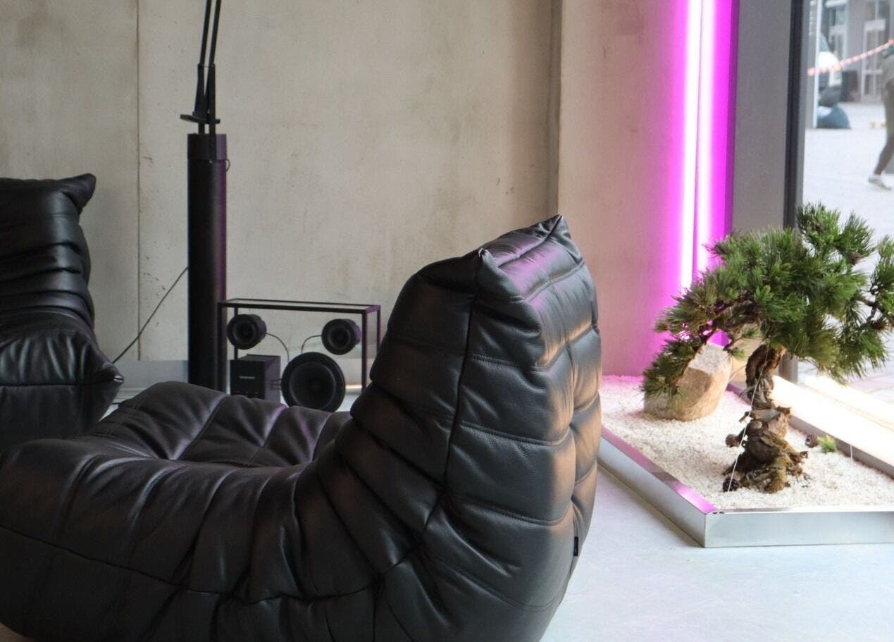 Modern lounge area at Usee Tattoo Atelier, Berlin, Berlin, DE with black leather seating and ambient lighting.