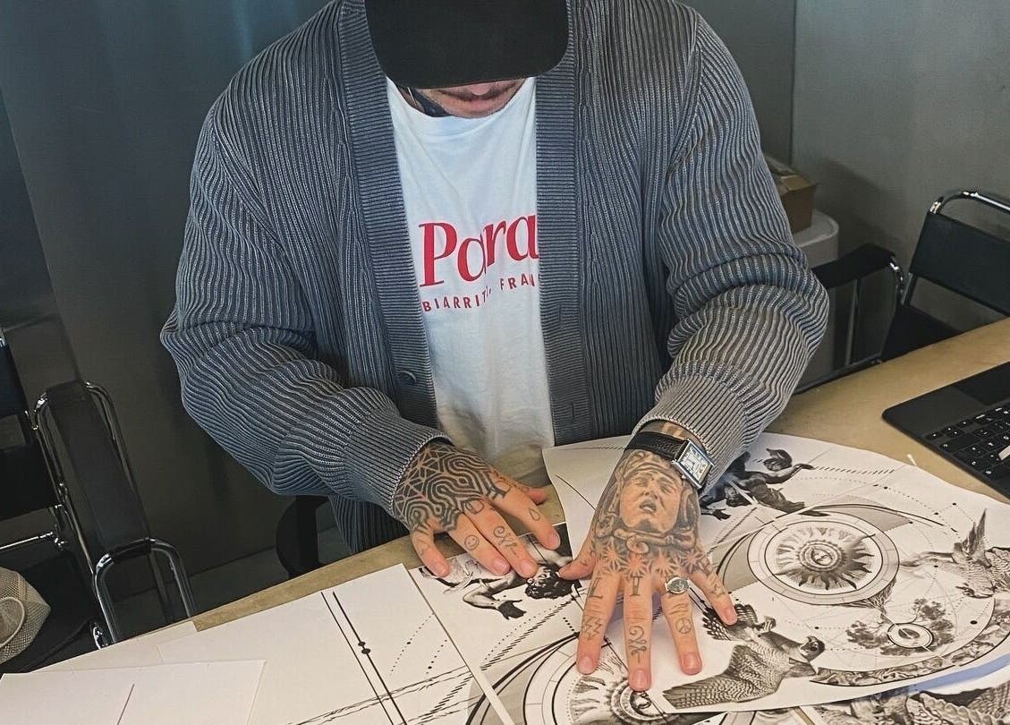 Tattoo artist at Usee Tattoo Atelier in Berlin, Berlin, DE, sketches intricate designs on paper.