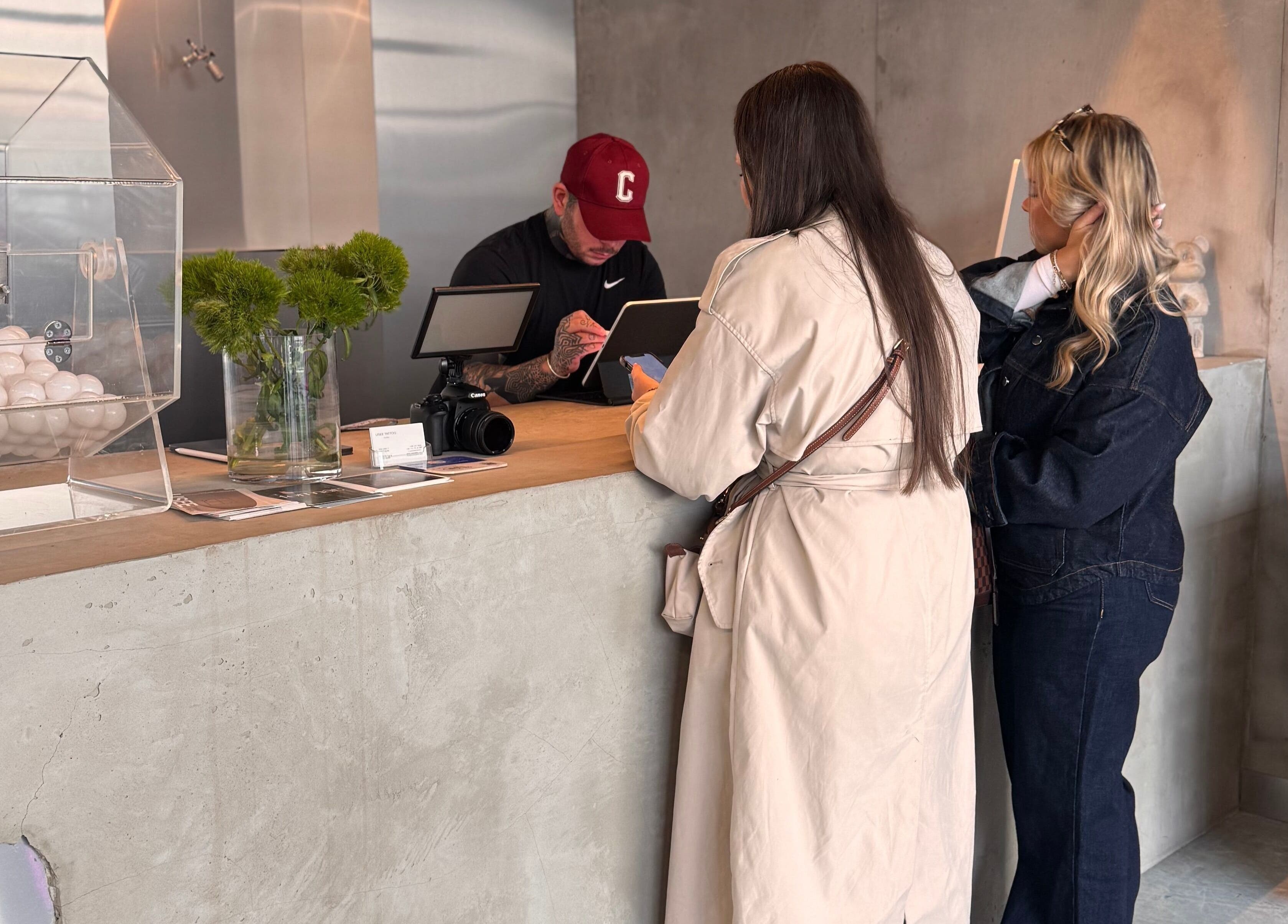 Clients consult at Usee Tattoo Atelier's modern reception in Berlin, Berlin, DE for personalized tattoo services.