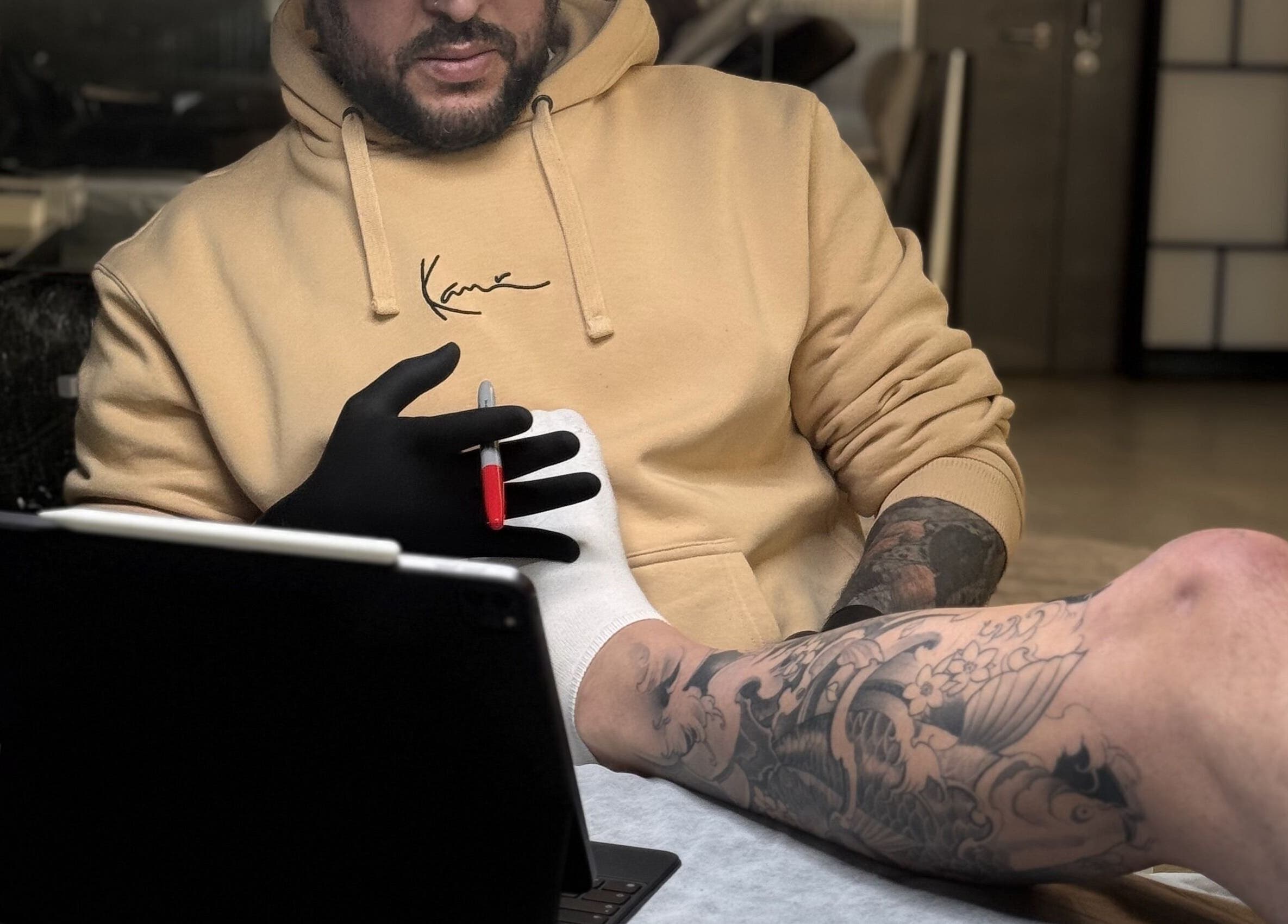 Artist designing tattoo at Usee Tattoo Atelier, Berlin, Berlin, DE.