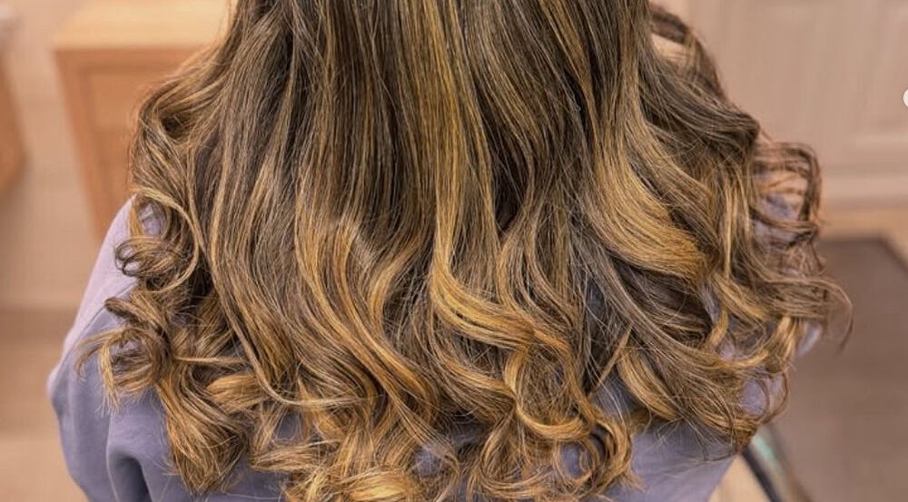 Elegant curled hairstyle at Elegance Studio, Ballygar, County Galway, IE, showcasing a blend of golden hues.