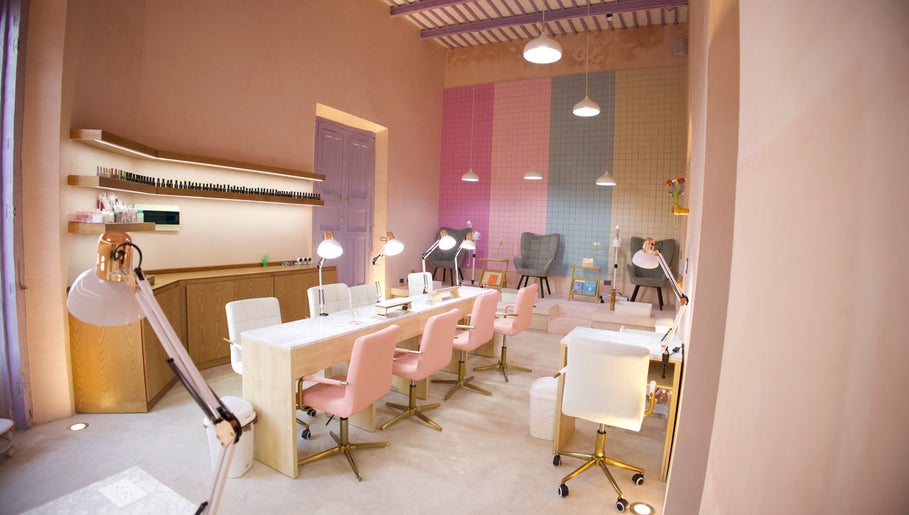 Área interior de Ceremonia Uñas | Spa - Centro de Mérida, con sillas rosas y decoración moderna en Mérida, Yucatán, MX.