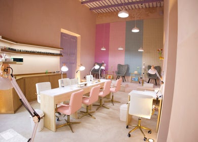 Área interior de Ceremonia Uñas | Spa - Centro de Mérida, con sillas rosas y decoración moderna en Mérida, Yucatán, MX.