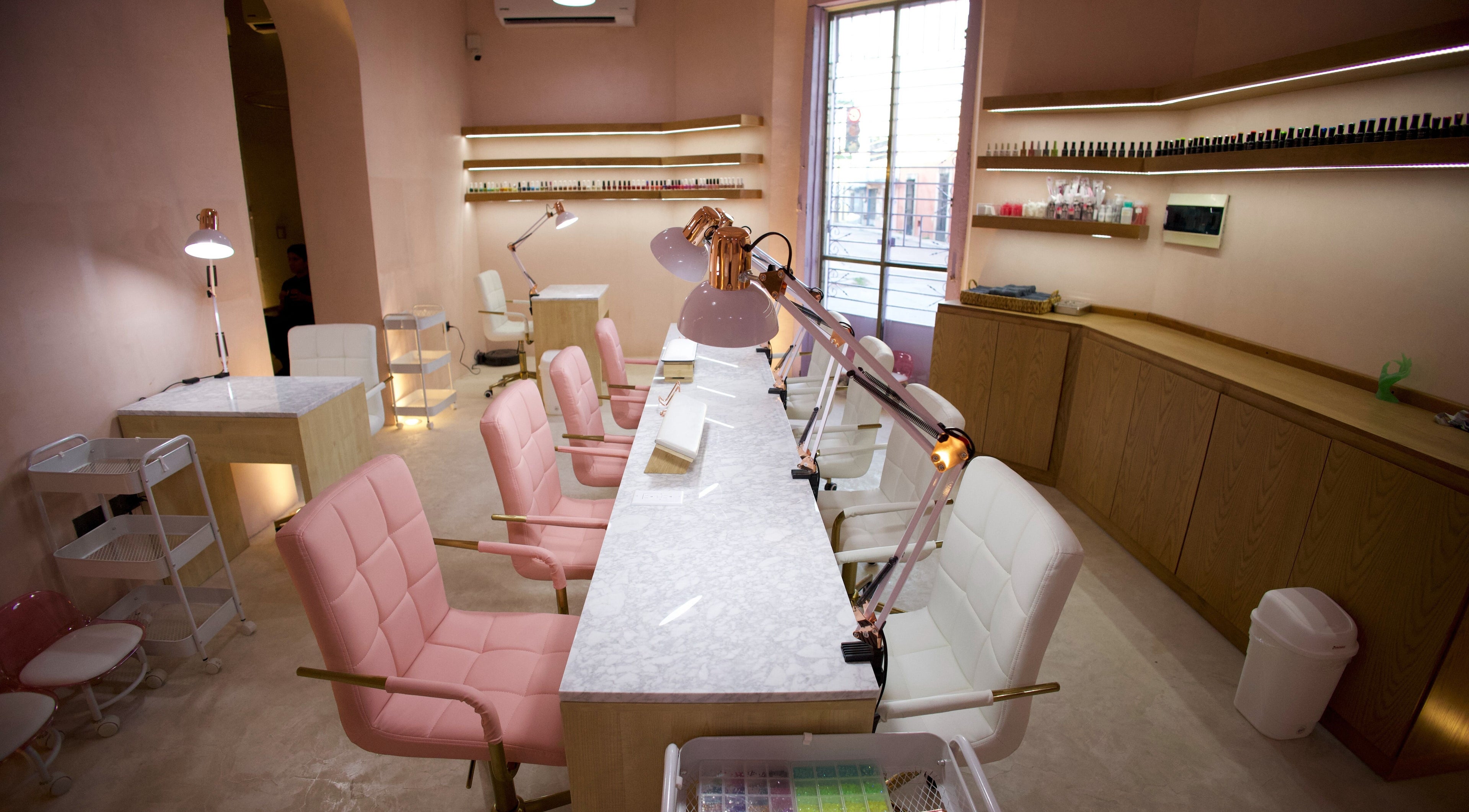 Interior elegante de Ceremonia Uñas | Spa - Centro de Mérida, Mérida, Yucatán, MX, con asientos rosas y blancos.