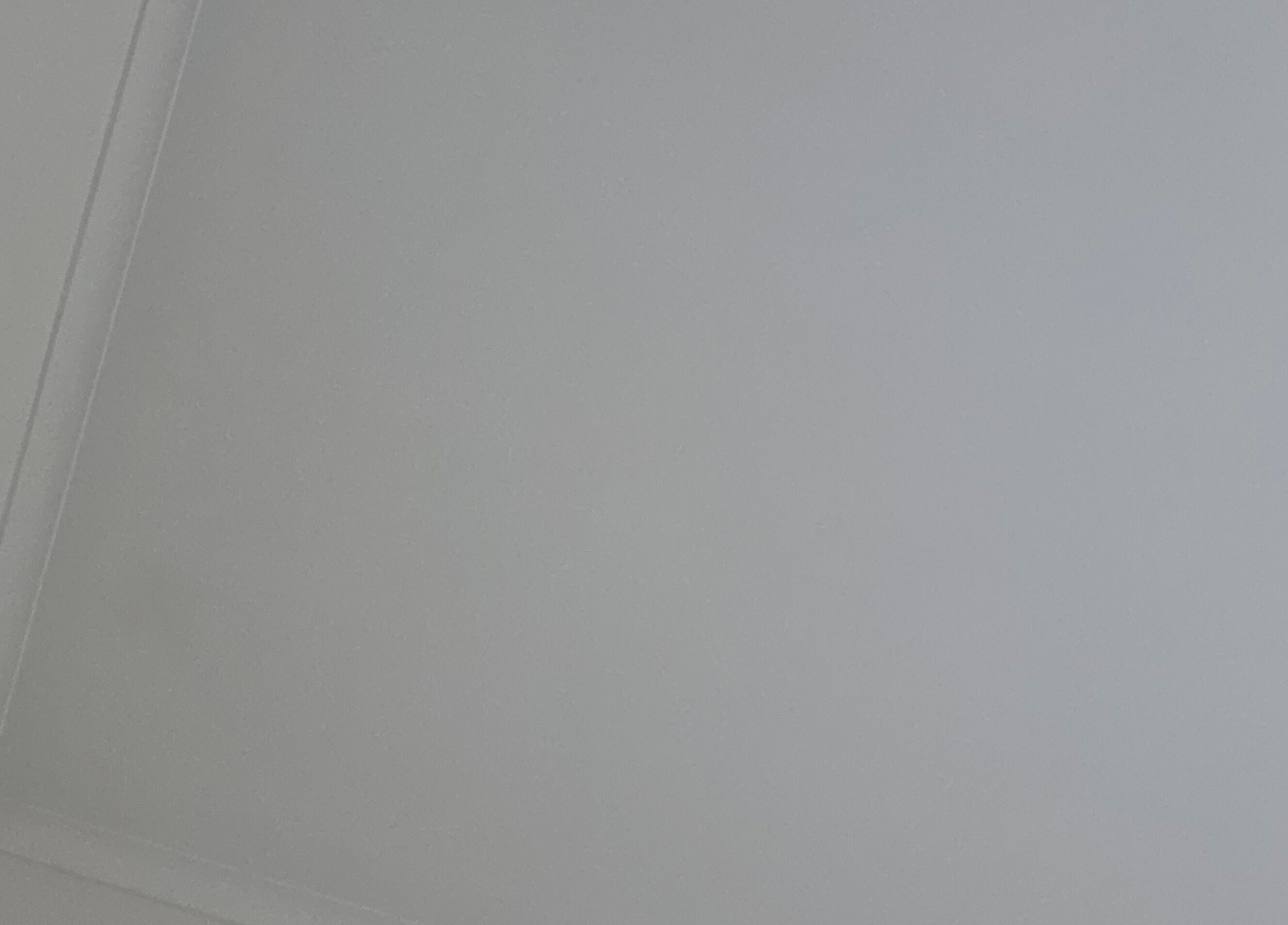 Minimalistic ceiling view at Spray Tan in Melbourne, Victoria, AU, showing sleek, smooth surface.