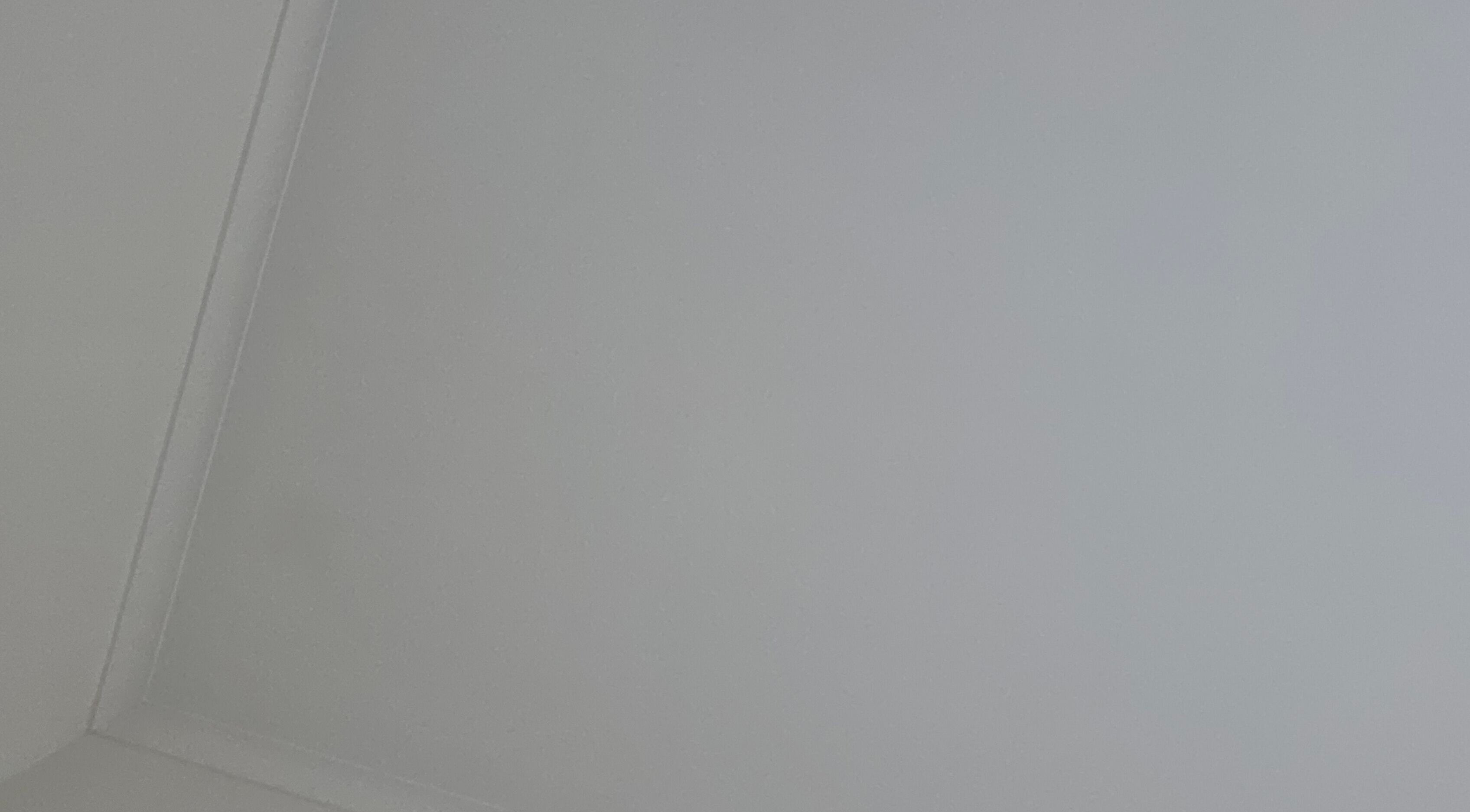 Minimalistic ceiling view at Spray Tan in Melbourne, Victoria, AU, showing sleek, smooth surface.