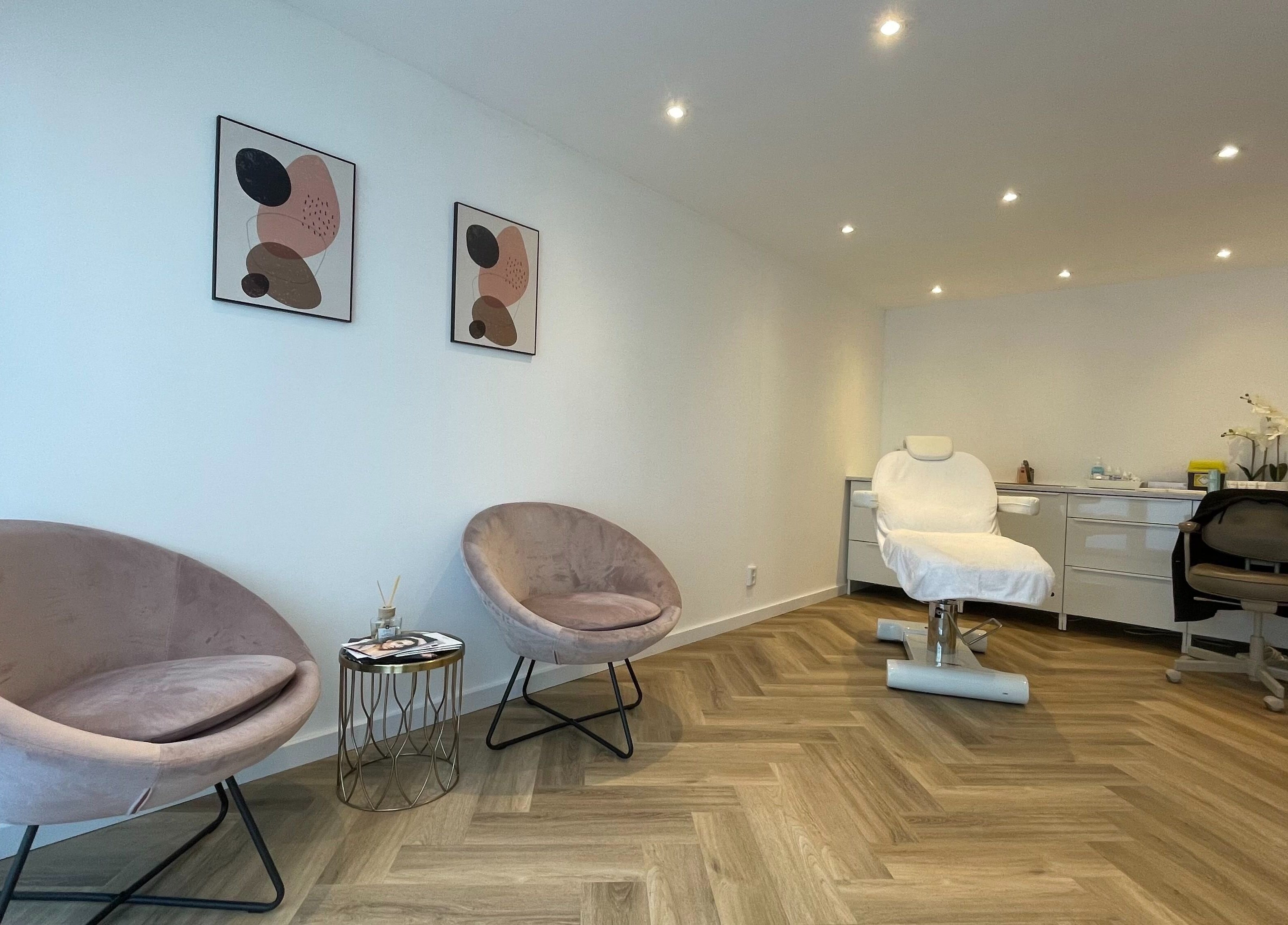 Moderne behandelkamer bij Clinic Eleven Aesthetics, Rotterdam, Zuid-Holland, NL, met comfortabele stoelen.