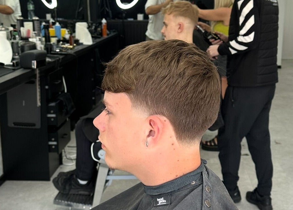 Man receiving a stylish haircut at Mattz Barbers in Birmingham, England, GB, showcasing modern grooming.