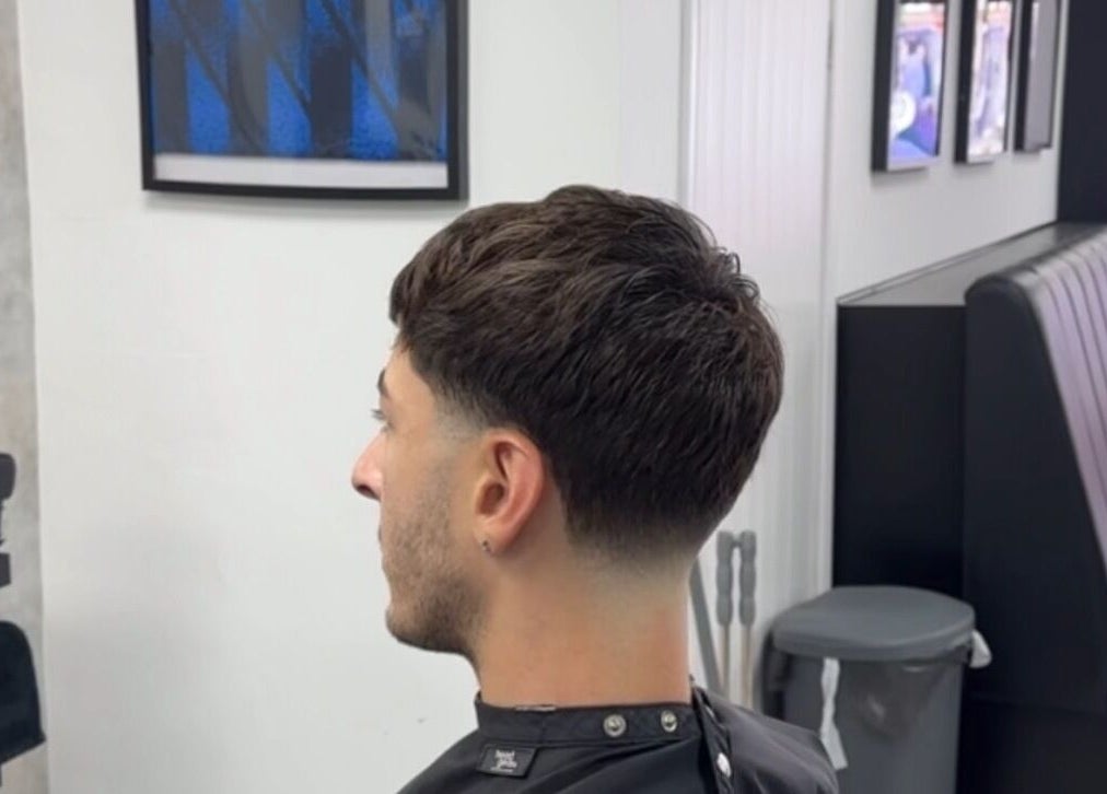 Stylish haircut at Mattz Barbers, Birmingham, England, GB, showcasing a modern fade in a sleek barbershop setting.