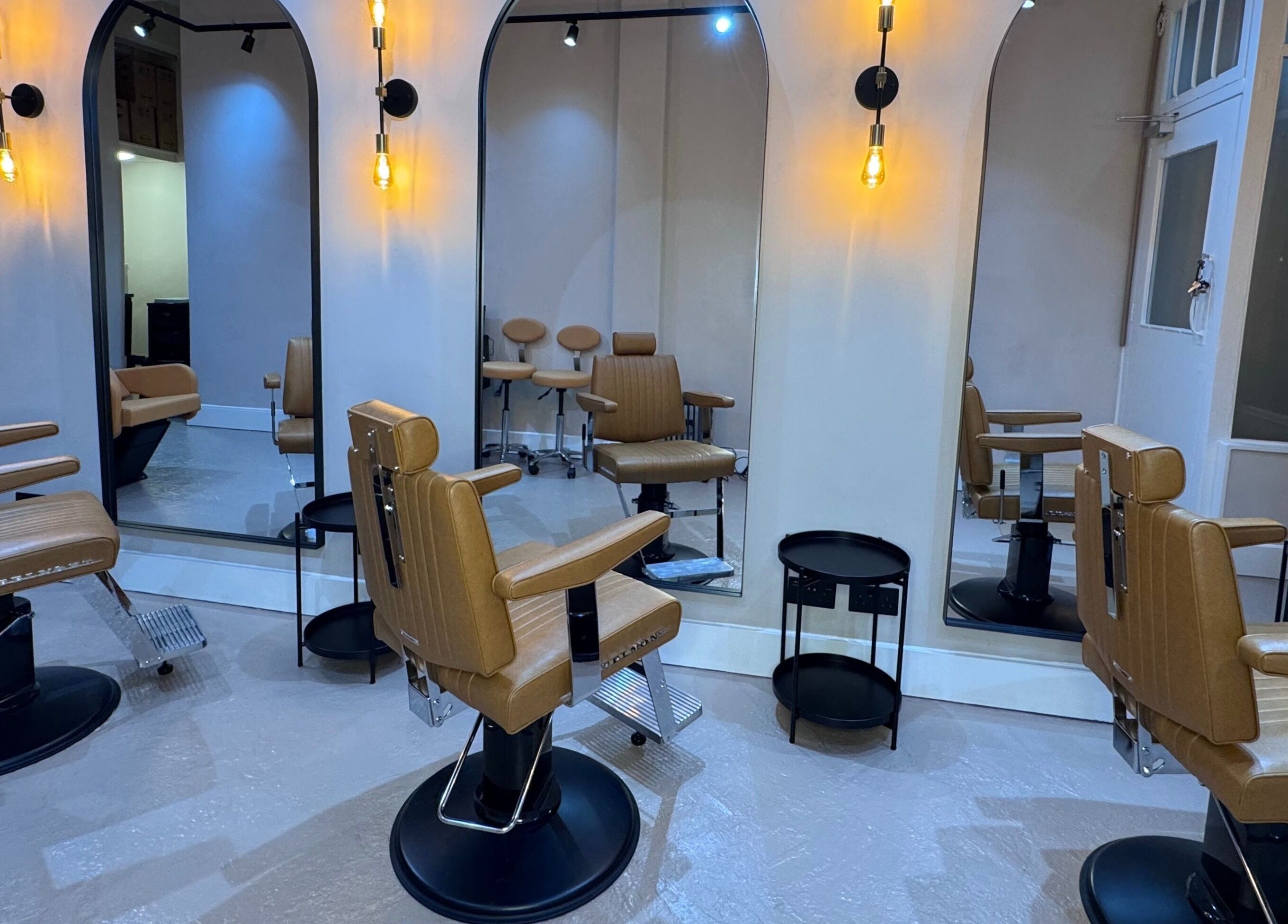 Chic barber chairs and mirrors at Yss Studio, London, England, GB, enhancing a modern wellness aesthetic.