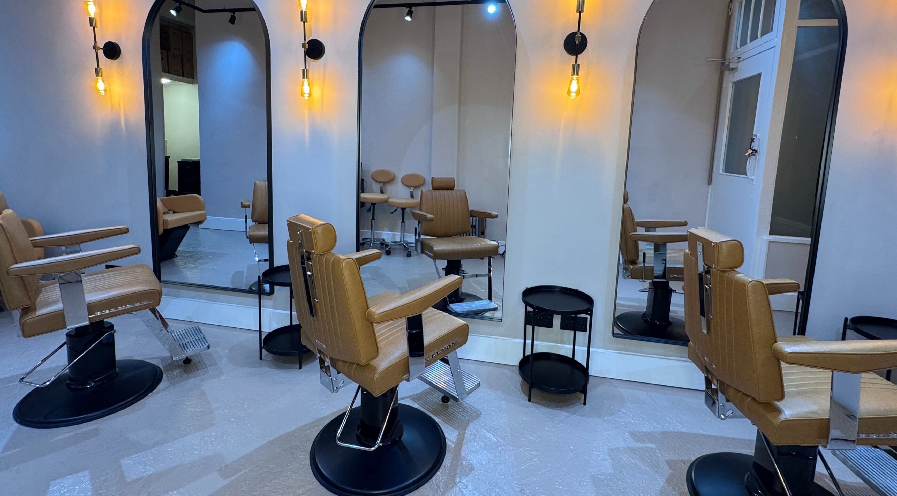 Chic barber chairs and mirrors at Yss Studio, London, England, GB, enhancing a modern wellness aesthetic.