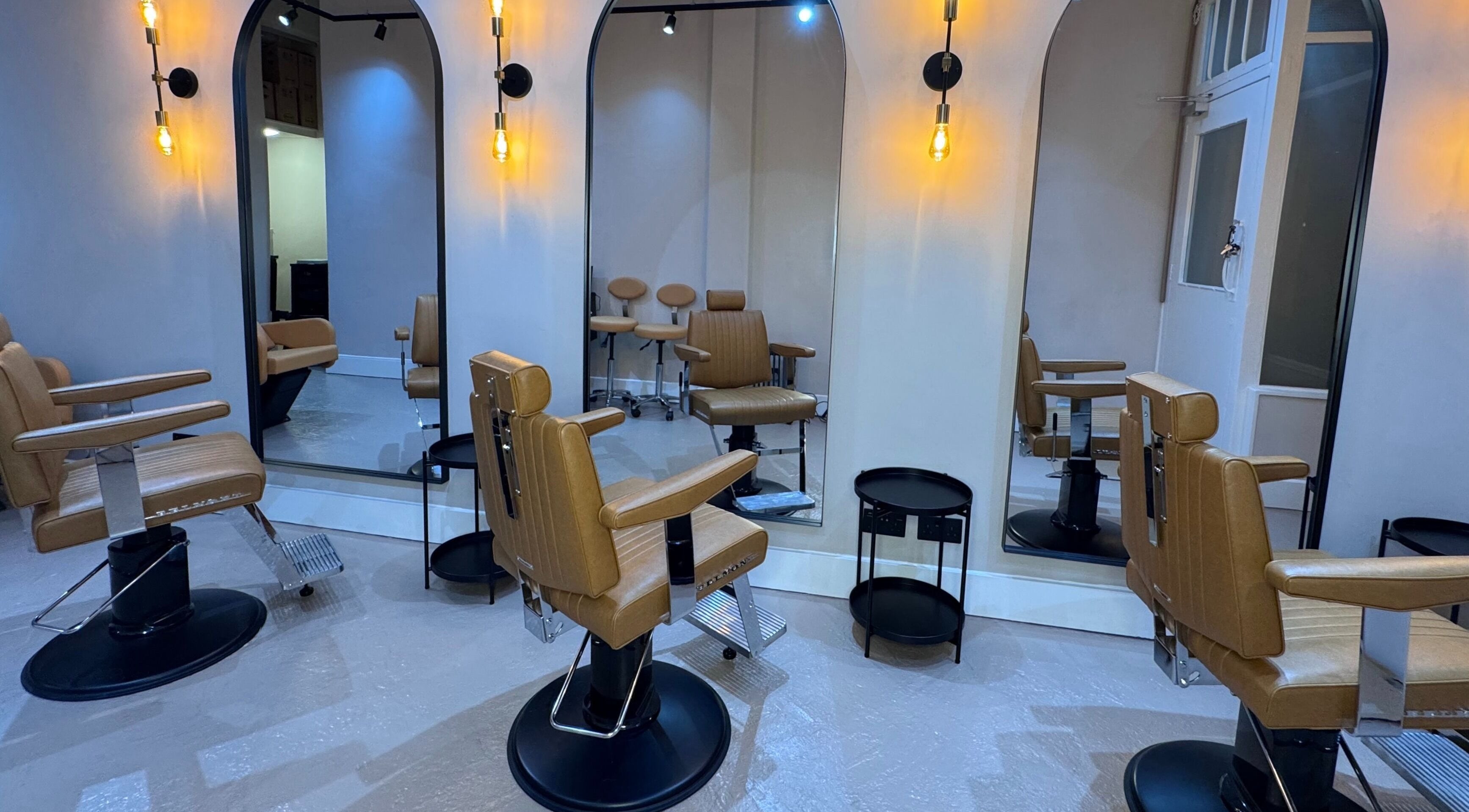 Chic barber chairs and mirrors at Yss Studio, London, England, GB, enhancing a modern wellness aesthetic.