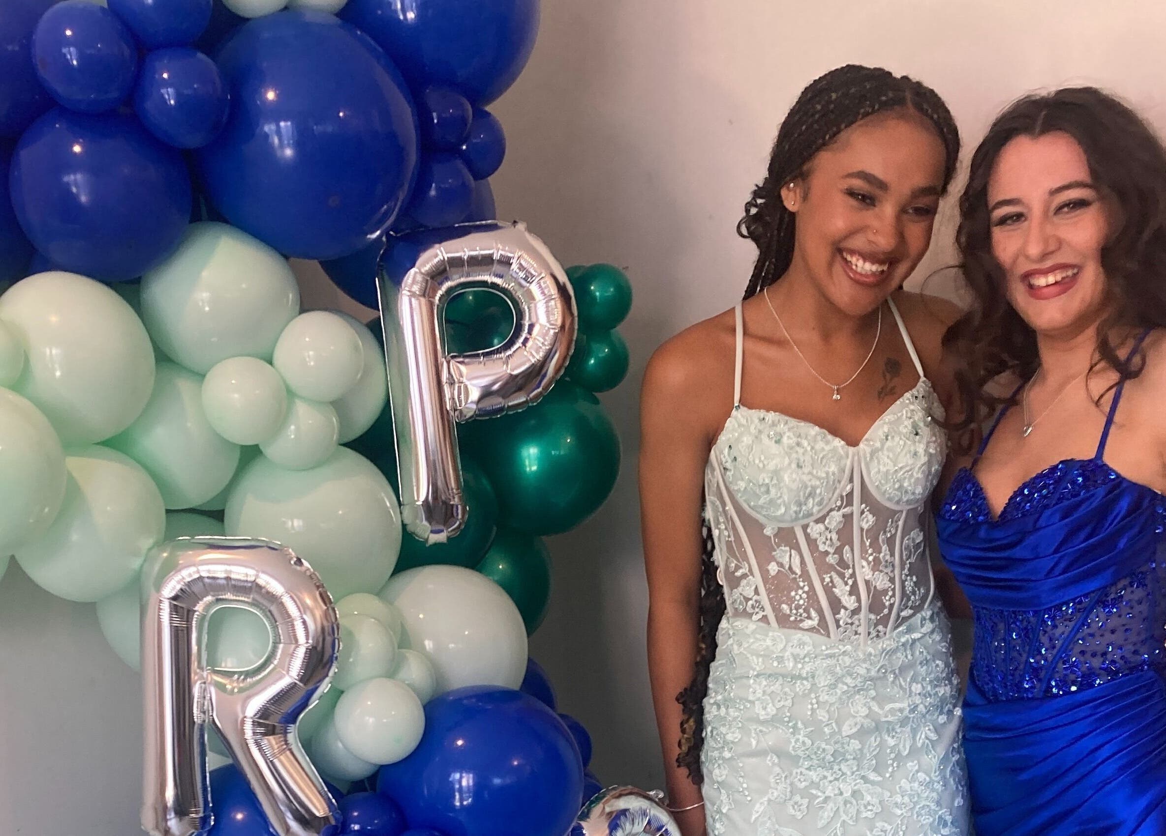 Two women in elegant dresses at Rita DeSario Make-Up Artist, Southampton, England, GB, with festive balloons.